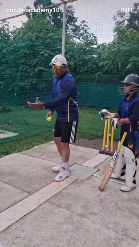 A coach demonstrating the bat swing beside a young batter