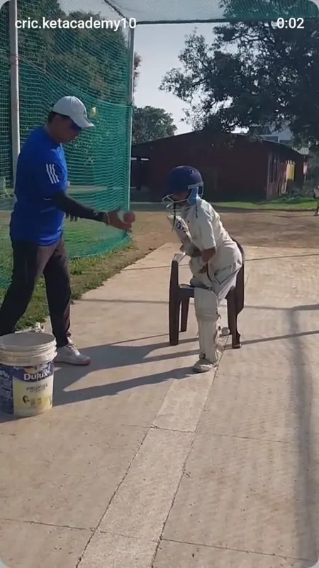 A coach guiding a young batter during a practice drill