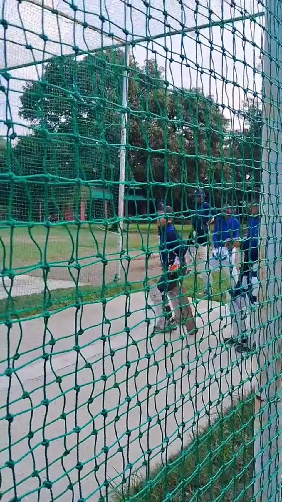 A young cricketer practising batting inside the academy nets